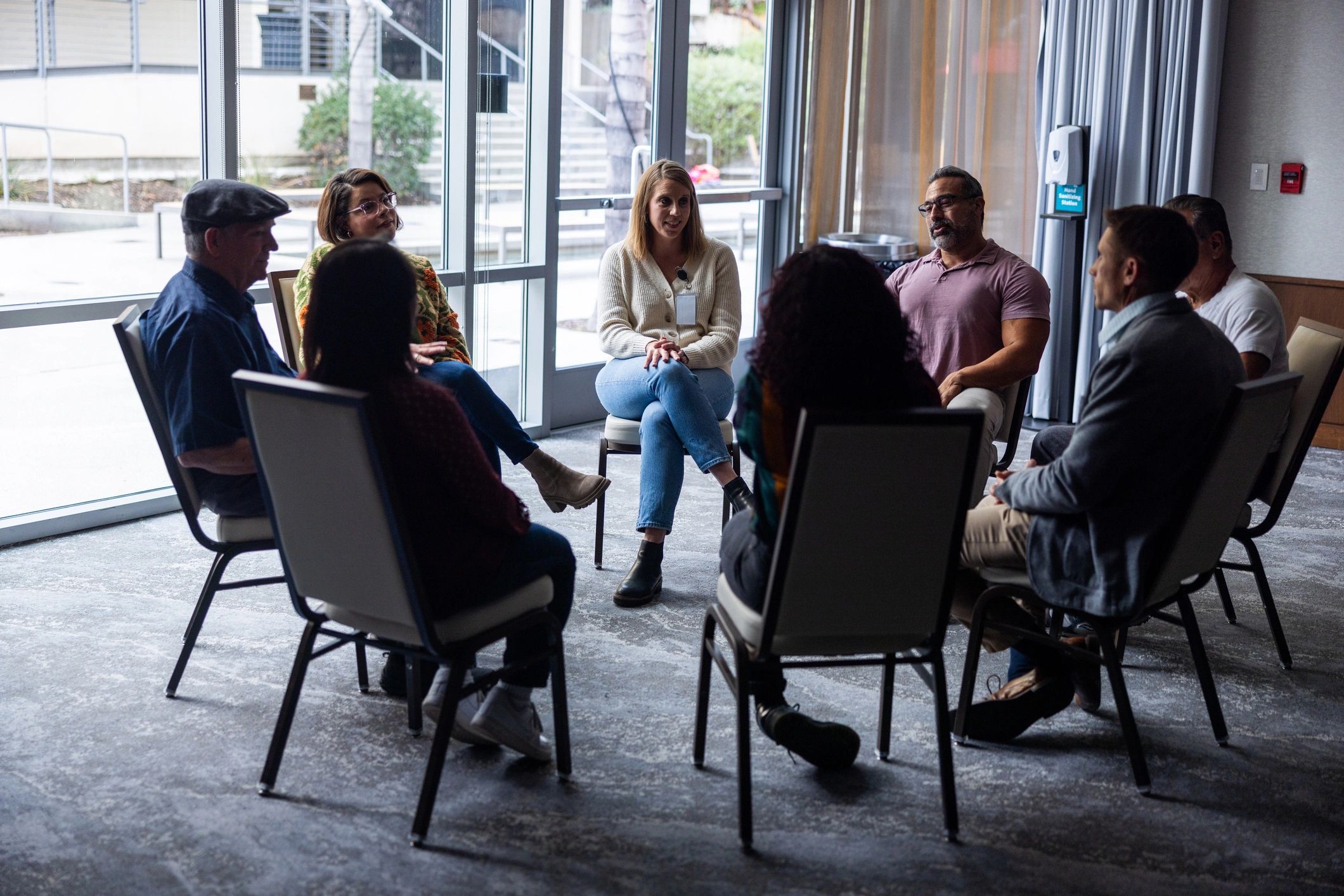 Wide shot of a group discussion near windows